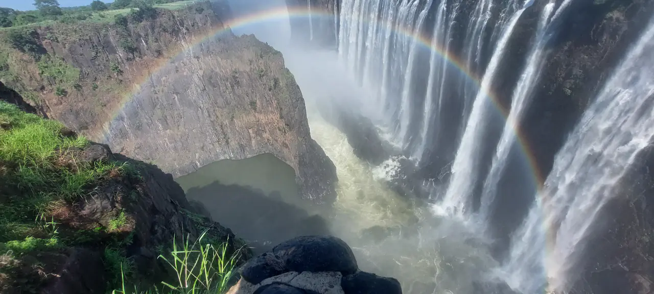 Rainbow arching across the spray of Victoria Falls