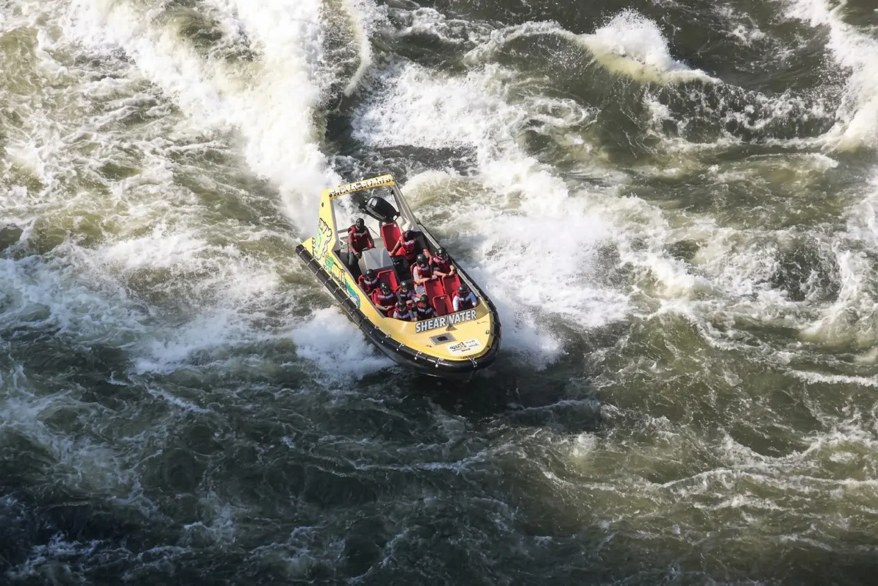 Boat powering through white-water rapids on the Zambezi